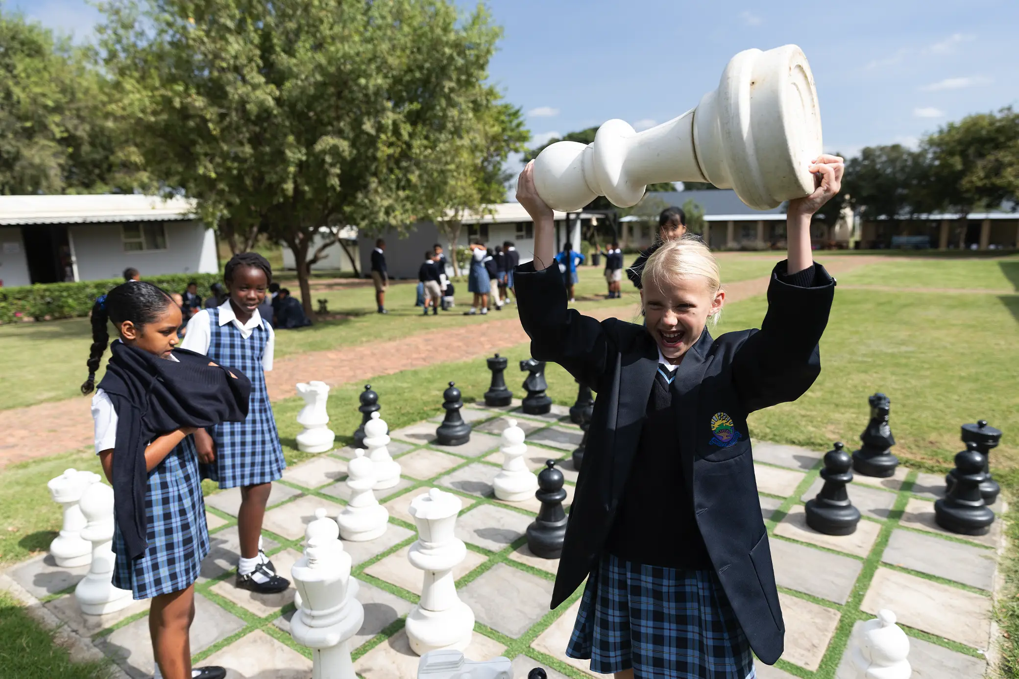 Students playing giant outdoor chess at Summerhill School